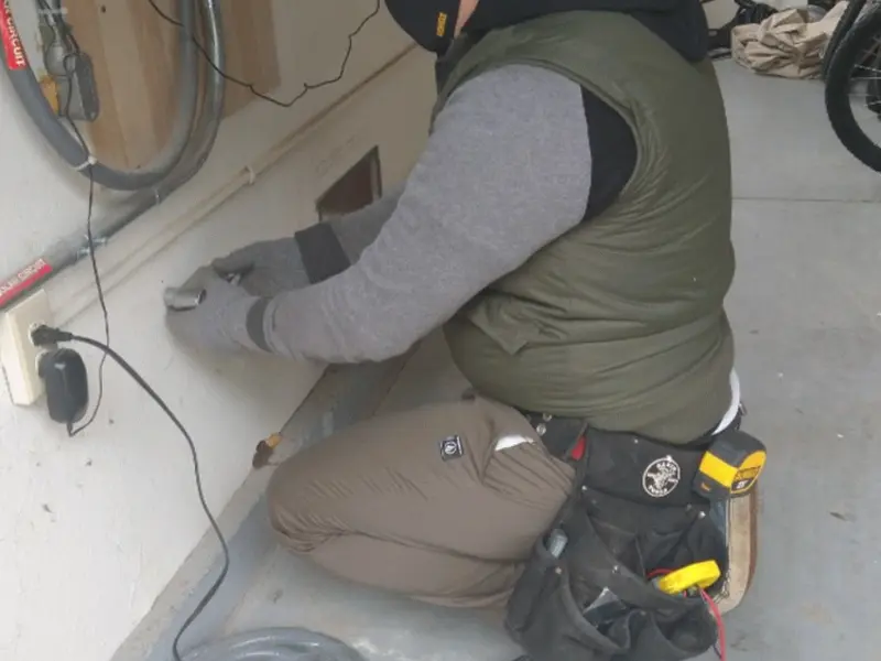 Electrician performing outlet wiring in a Marlborough garage